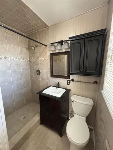 a bathroom with a toilet sink shower and mirror