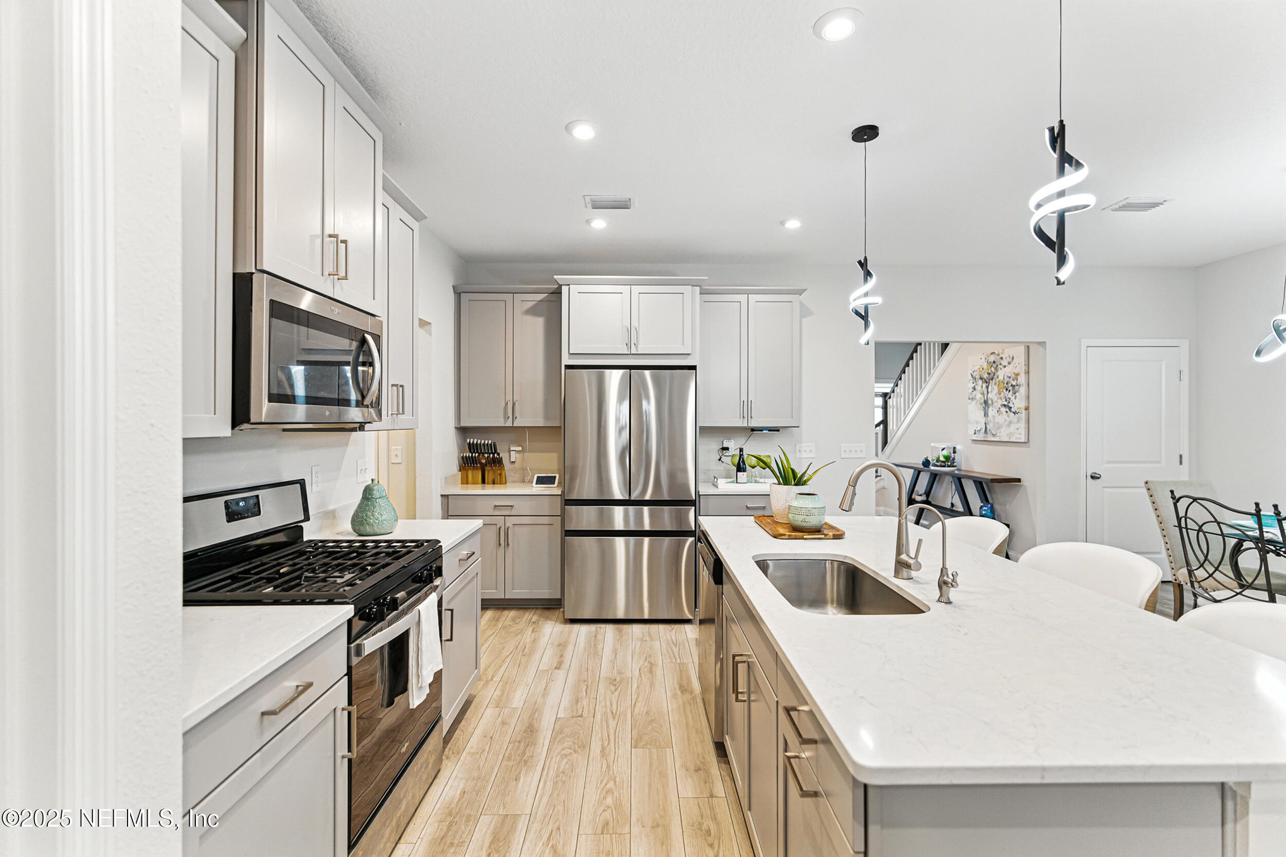 105 Meadow Creek Drive St. Johns, FL 32259 - Photo 14 of 37 a kitchen with a sink a stove top oven a refrigerator cabinets and living room view