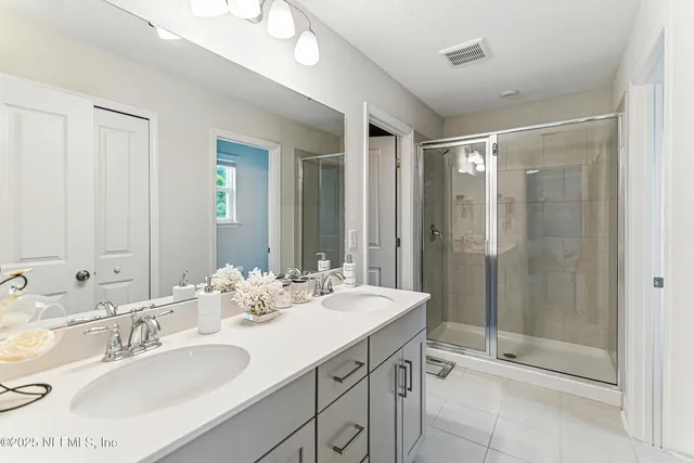 a bathroom with double sink and a mirror