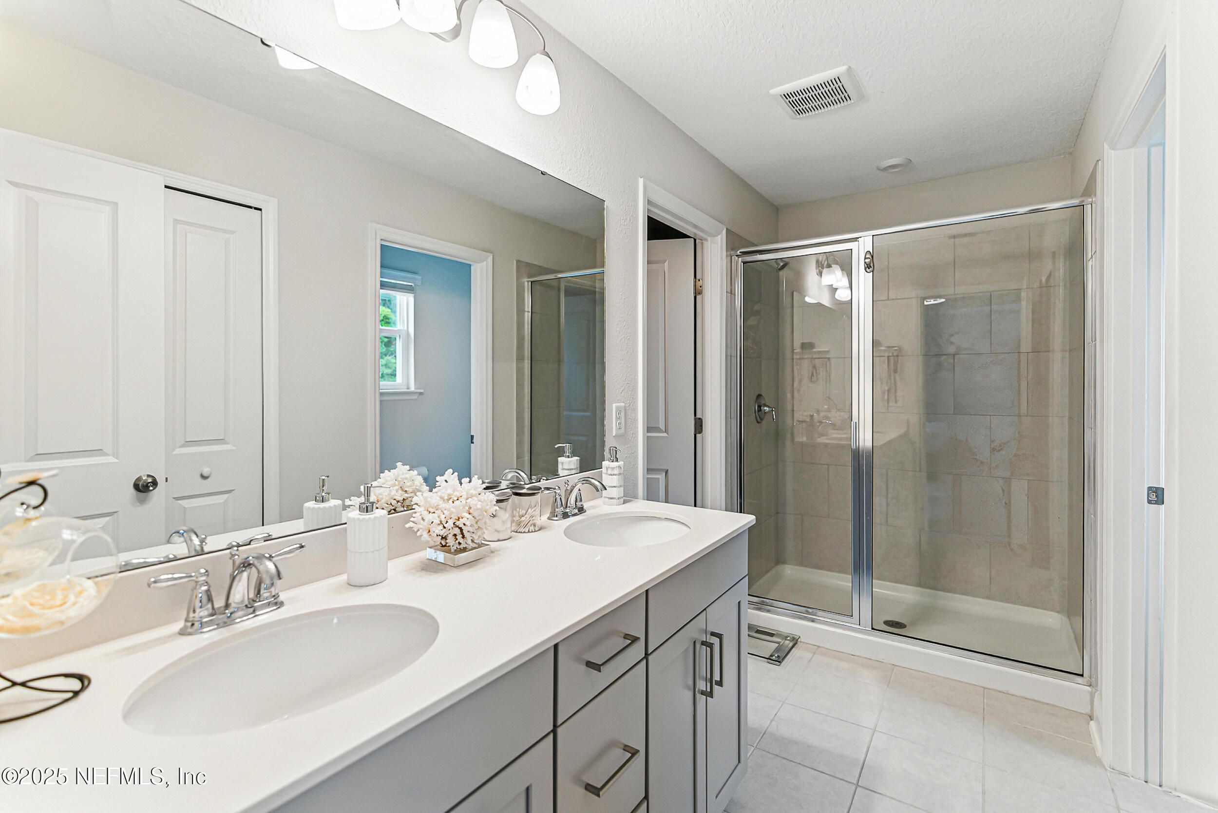 105 Meadow Creek Drive St. Johns, FL 32259 - Photo 19 of 37 a bathroom with double sink and a mirror