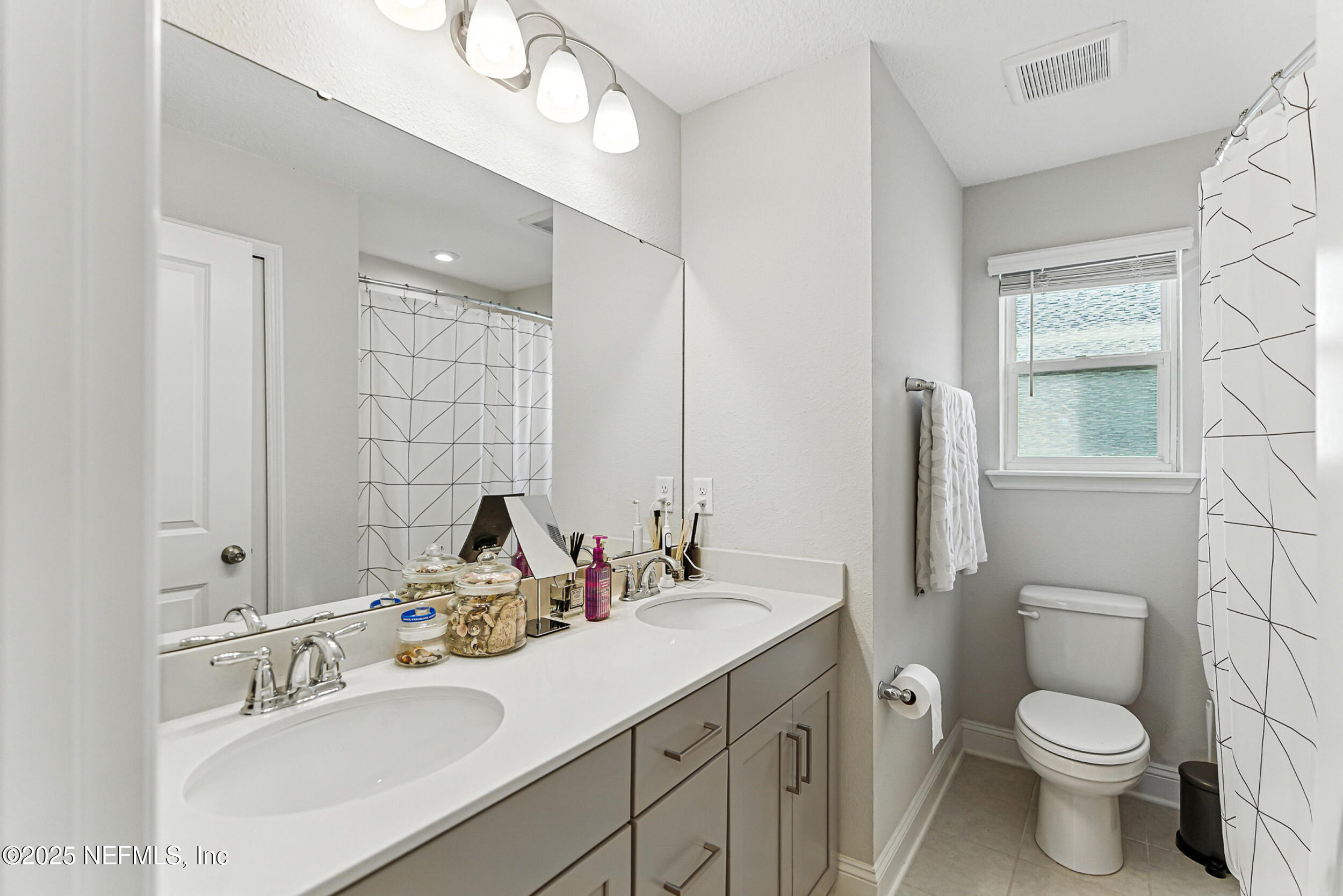 105 Meadow Creek Drive St. Johns, FL 32259 - Photo 22 of 37 a bathroom with a toilet sink double vanity and mirror