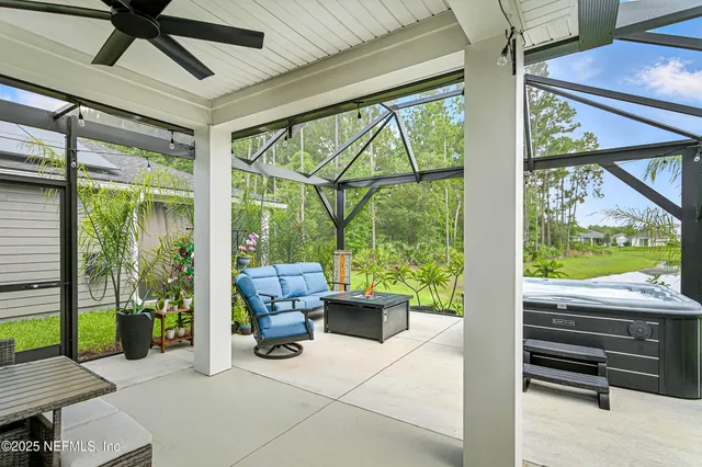a living room with patio furniture and a floor to ceiling window