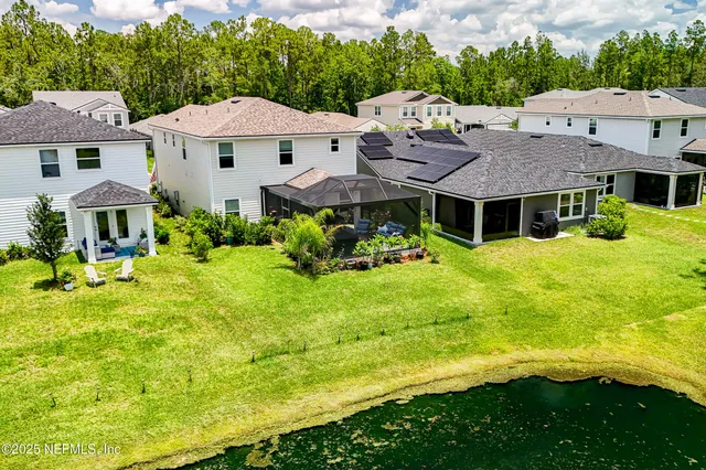 a aerial view of a house with swimming pool and green space