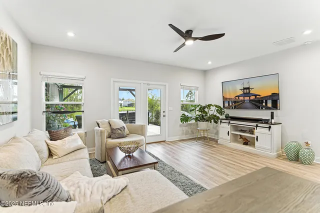 a living room with furniture a window and a flat screen tv