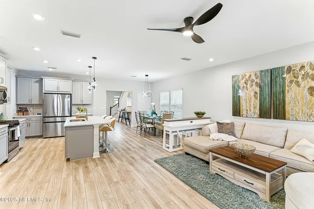 a living room with furniture and kitchen view