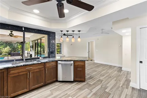 a large kitchen with stainless steel appliances granite countertop a sink and wooden floors
