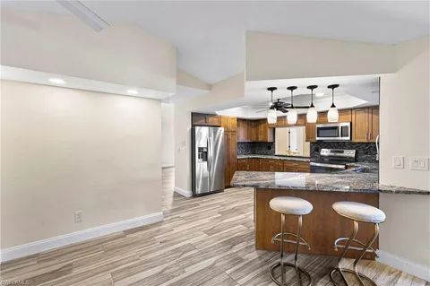 a kitchen with granite countertop white cabinets and stainless steel appliances