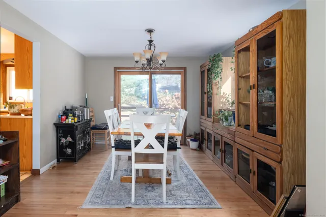 a dining room with wooden floor and windows