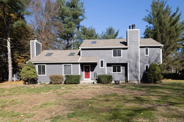 a front view of house with yard and trees around