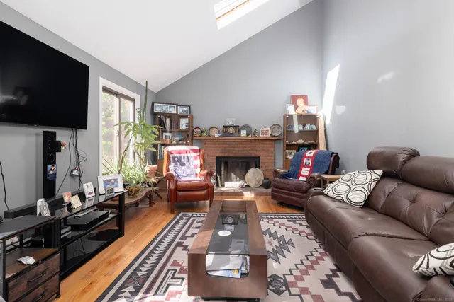 a living room with furniture a flat screen tv and a fireplace