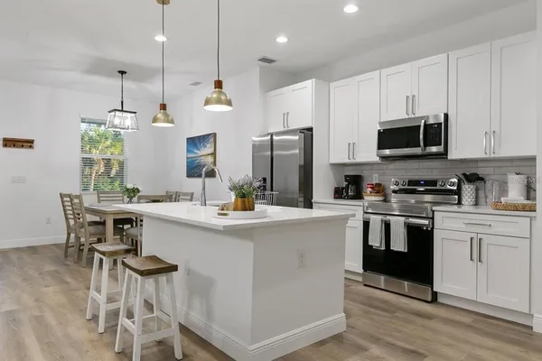 a kitchen with kitchen island granite countertop a sink a counter top space stainless steel appliances and cabinets