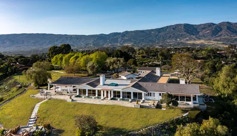 an aerial view of residential houses with outdoor space and river