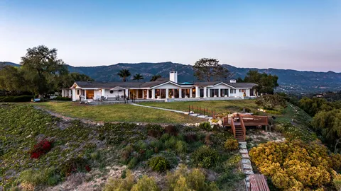 an aerial view of residential houses with yard and mountain view in back