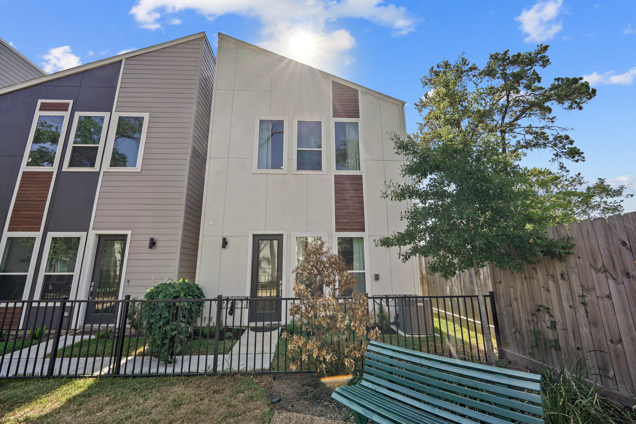 a front view of a house with glass windows and plants