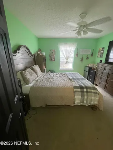 a bedroom with a bed mirror and window
