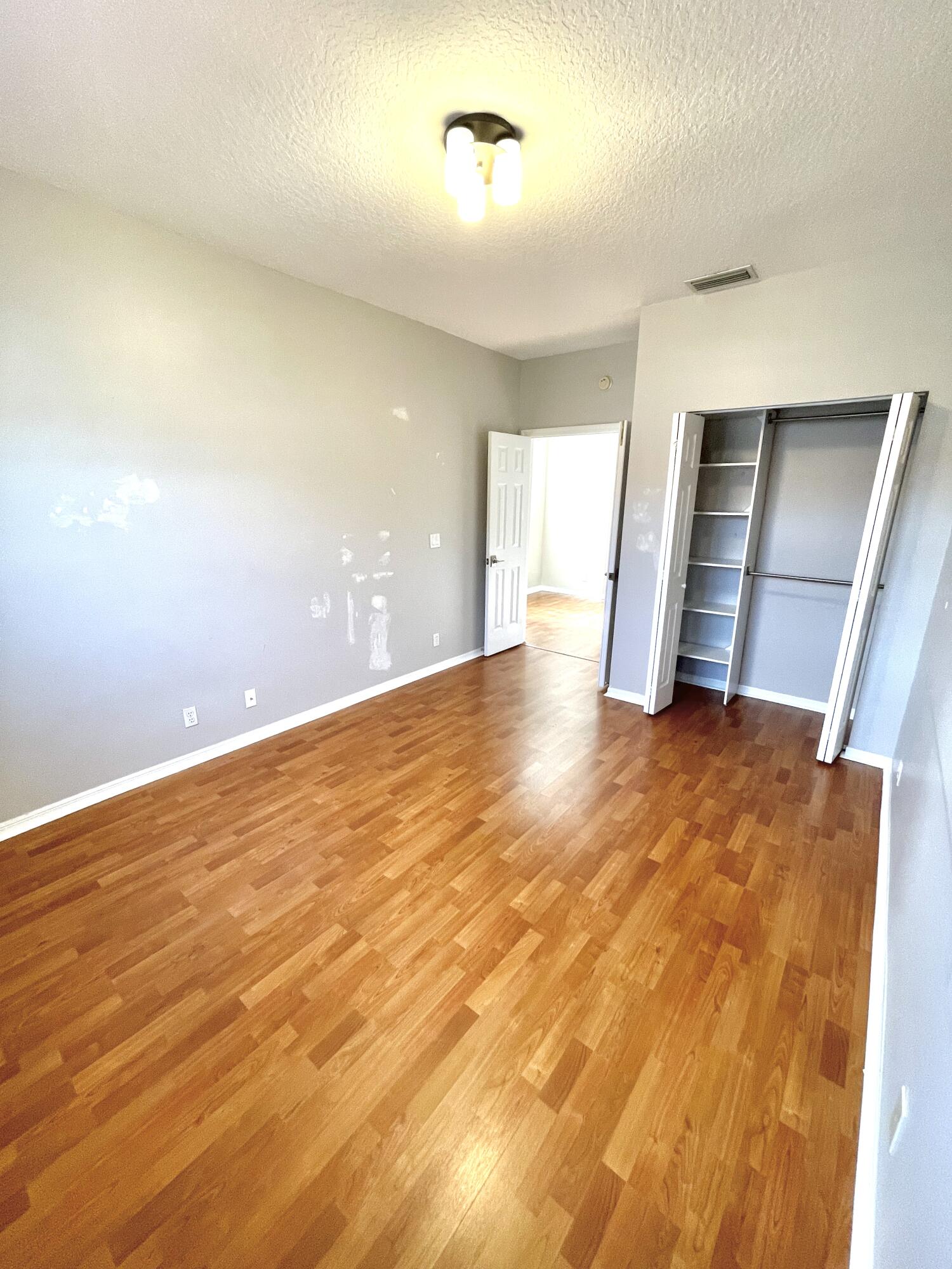 8550 Vía Romana, Unit 2 Boca Raton, FL 33496 - Photo 21 of 28 an empty room with wooden floor and windows