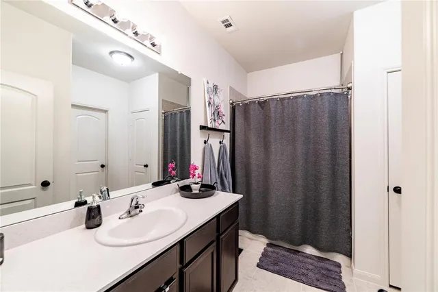 a bathroom with double vanity sink and a mirror