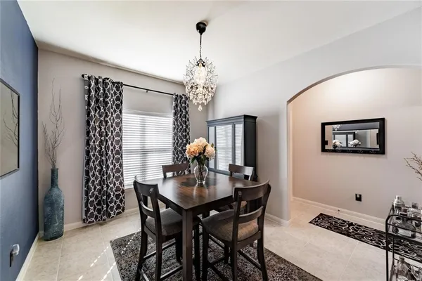 a dining room with furniture a chandelier and window