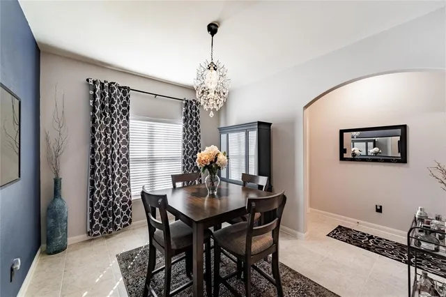 a dining room with furniture a chandelier and window