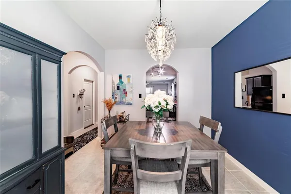 a view of a dining room with furniture a chandelier and wooden floor