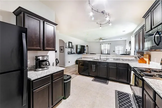 a kitchen with stainless steel appliances granite countertop a stove refrigerator and cabinets