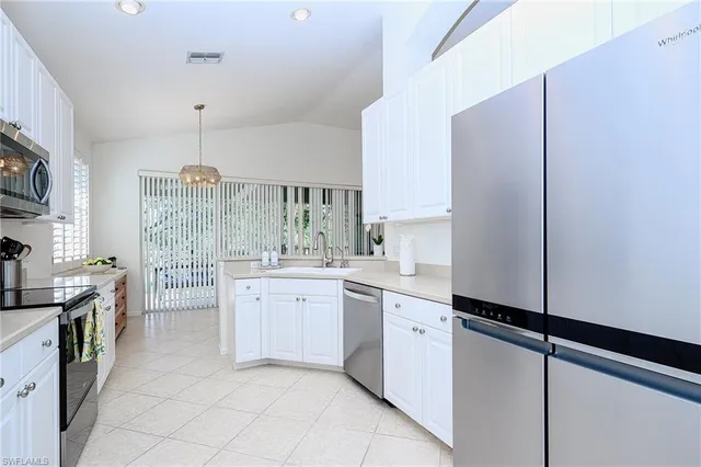 a large white kitchen with cabinets