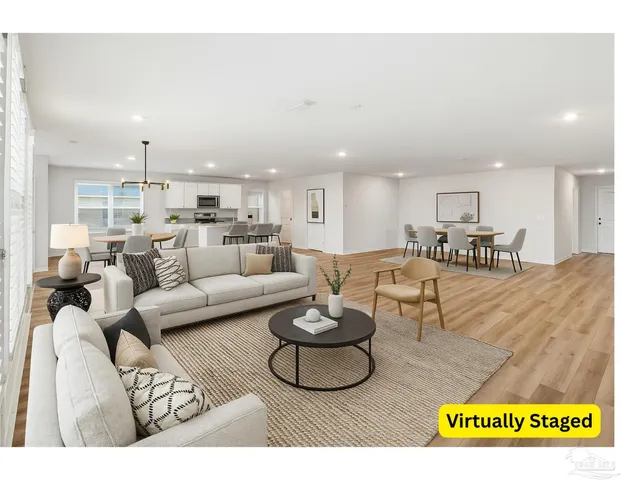a living room with furniture a kitchen view and a dining table