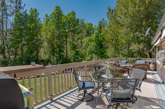 a view of a chairs and table in a patio with a barbeque grill