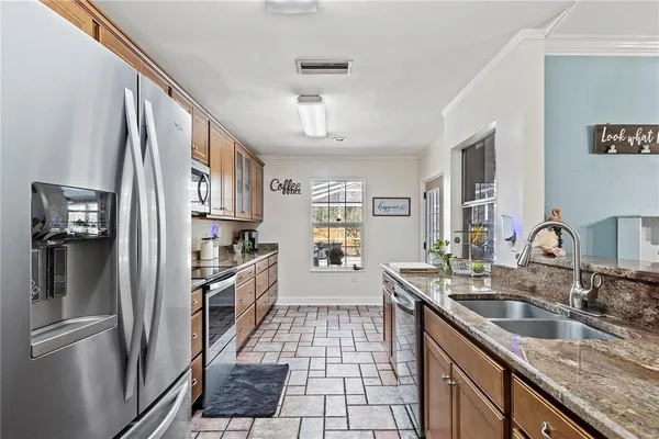 a kitchen with granite countertop a stove microwave and sink