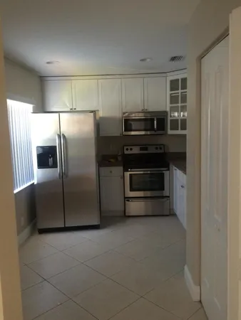 a kitchen with a refrigerator sink and cabinets