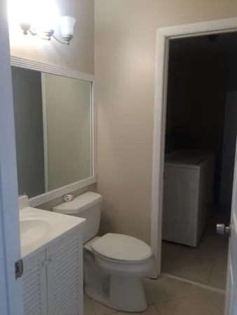 a bathroom with a toilet a sink and mirror