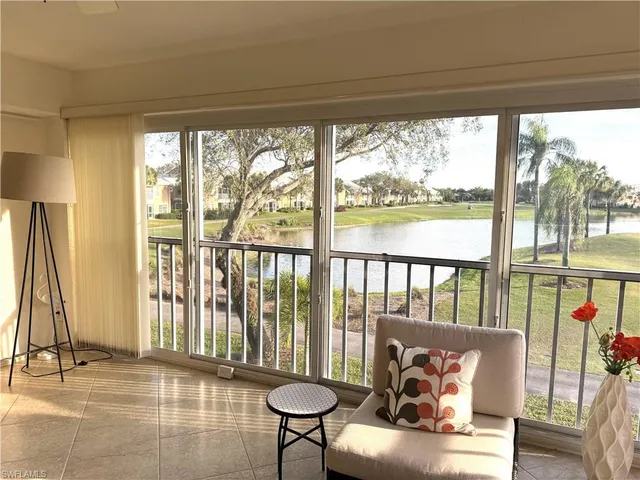 a living room with furniture and a floor to ceiling window