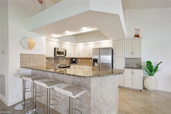 a kitchen with stainless steel appliances kitchen island granite countertop a sink and cabinets