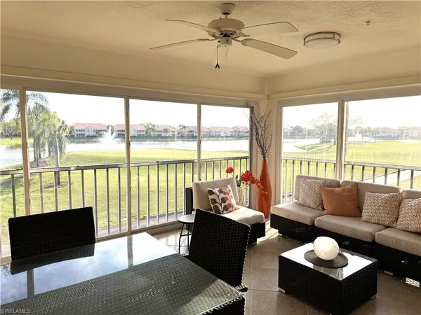a living room with furniture and floor to ceiling windows