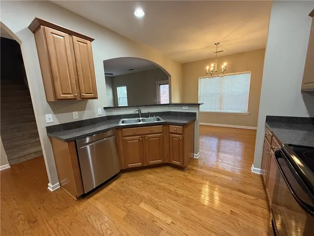 a kitchen with stainless steel appliances granite countertop a stove a sink and a microwave