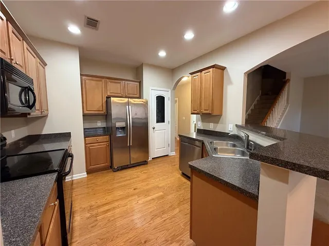 a kitchen with stainless steel appliances granite countertop a refrigerator and a stove top oven