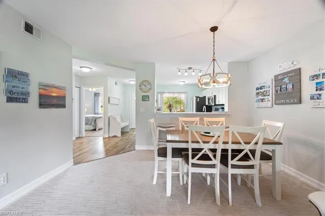 a dining room with furniture a chandelier and wooden floor