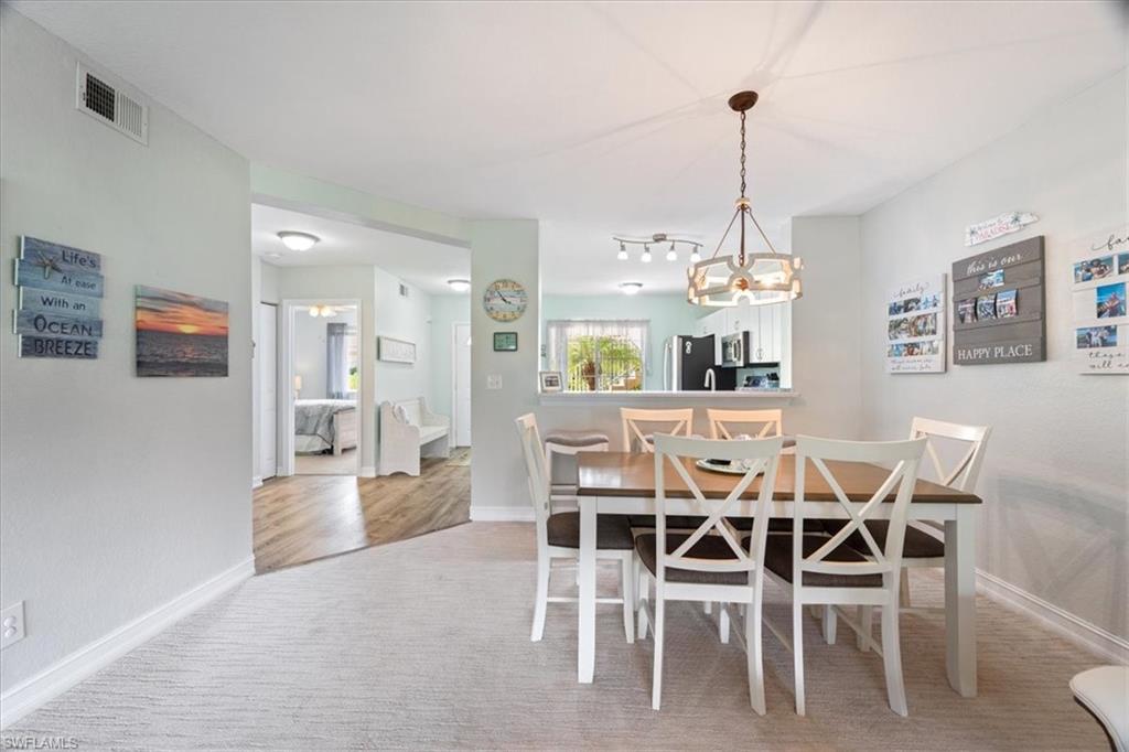 a dining room with furniture a chandelier and wooden floor