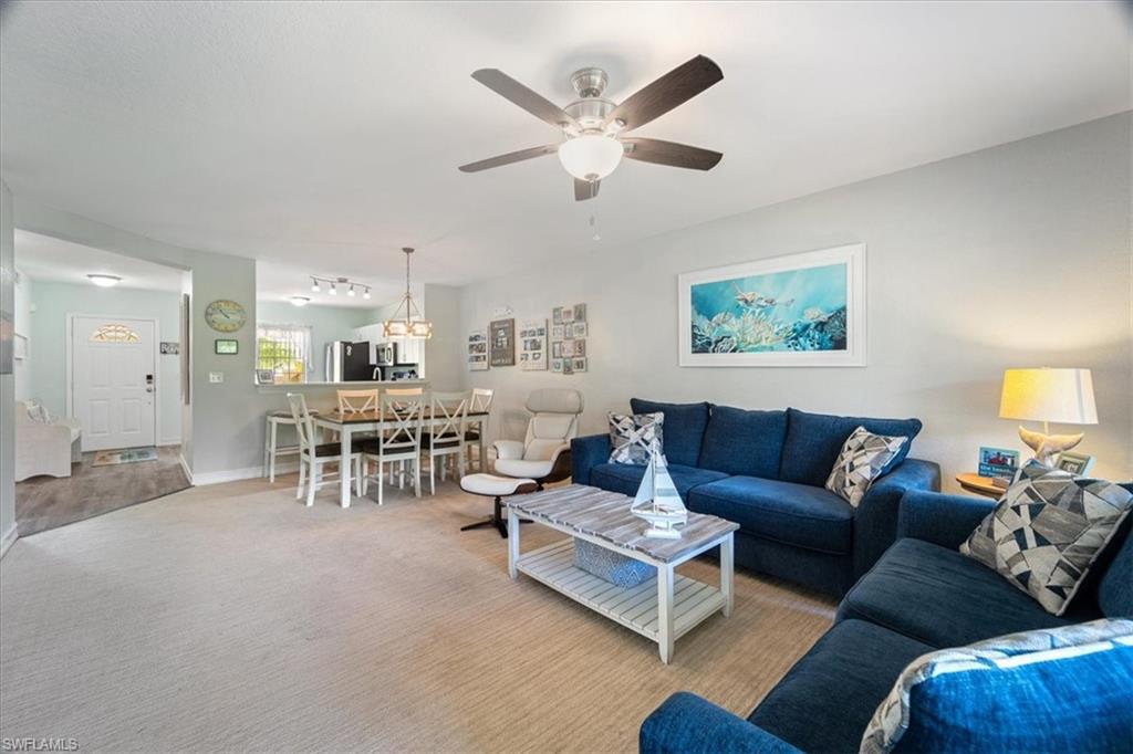 1715 Reuven Circle, Unit 2103 Naples, FL 34112 - Photo 12 of 38 a living room with furniture and a chandelier