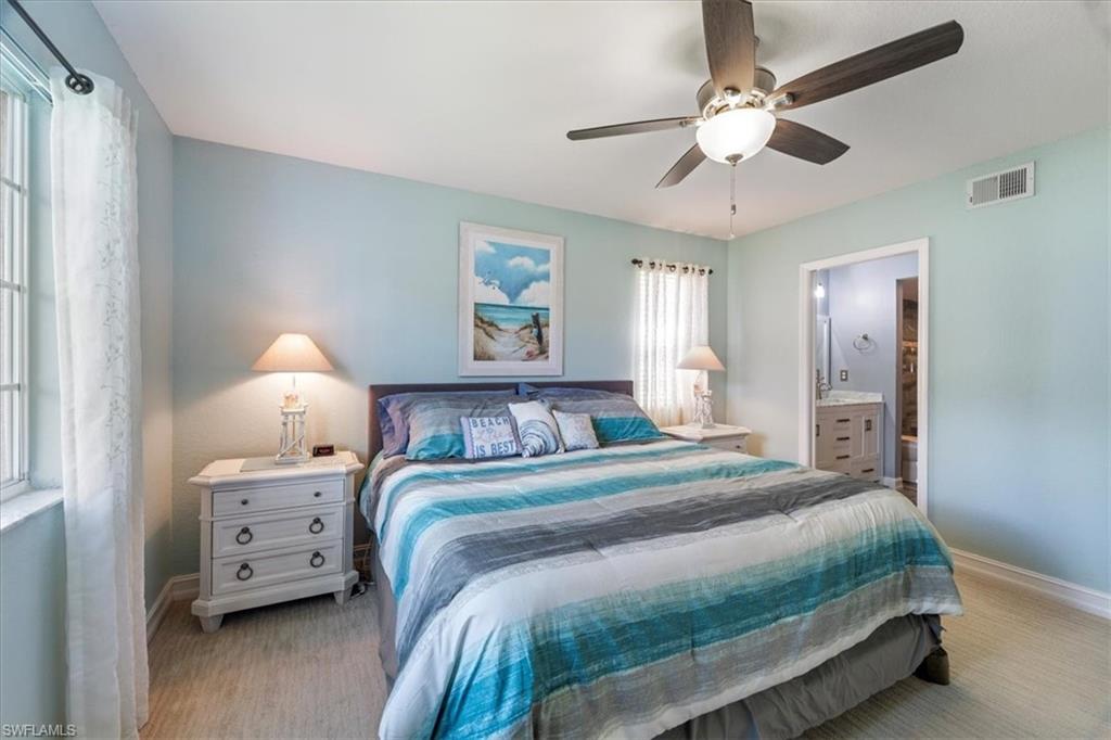 1715 Reuven Circle, Unit 2103 Naples, FL 34112 - Photo 15 of 38 Bedroom with a ceiling fan, ensuite bath, and light carpet