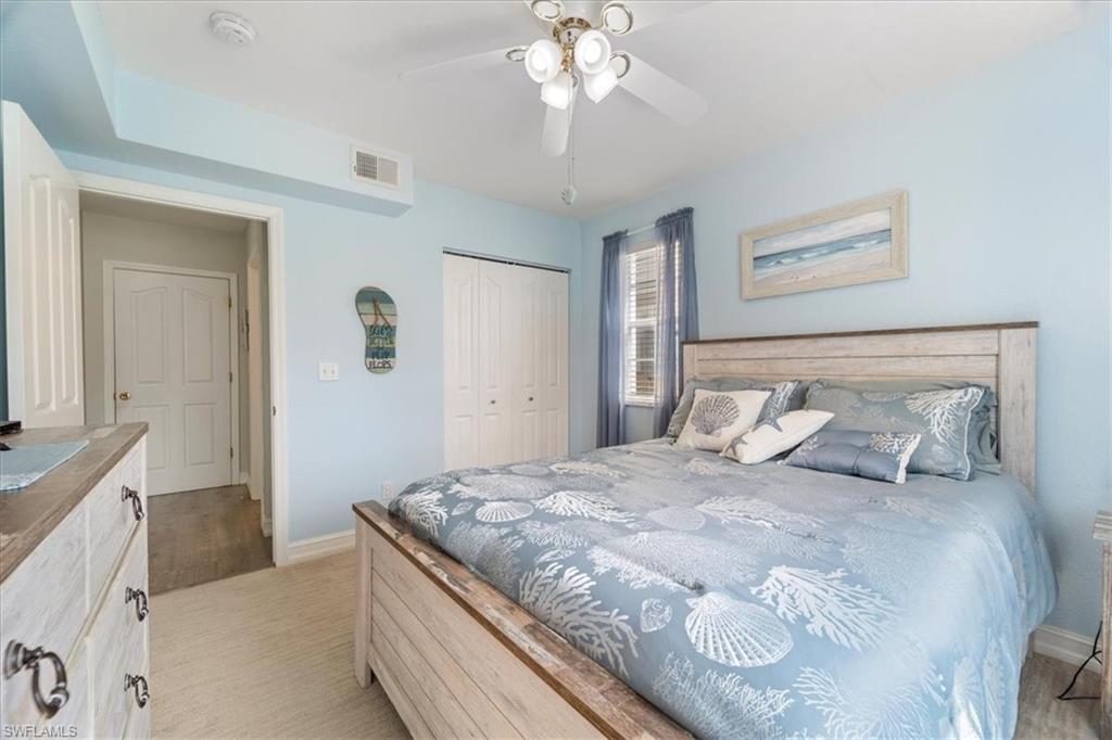 1715 Reuven Circle, Unit 2103 Naples, FL 34112 - Photo 21 of 38 a bedroom with a large bed and a chandelier