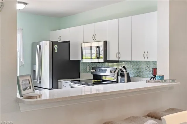 a kitchen with stainless steel appliances white cabinets and a sink