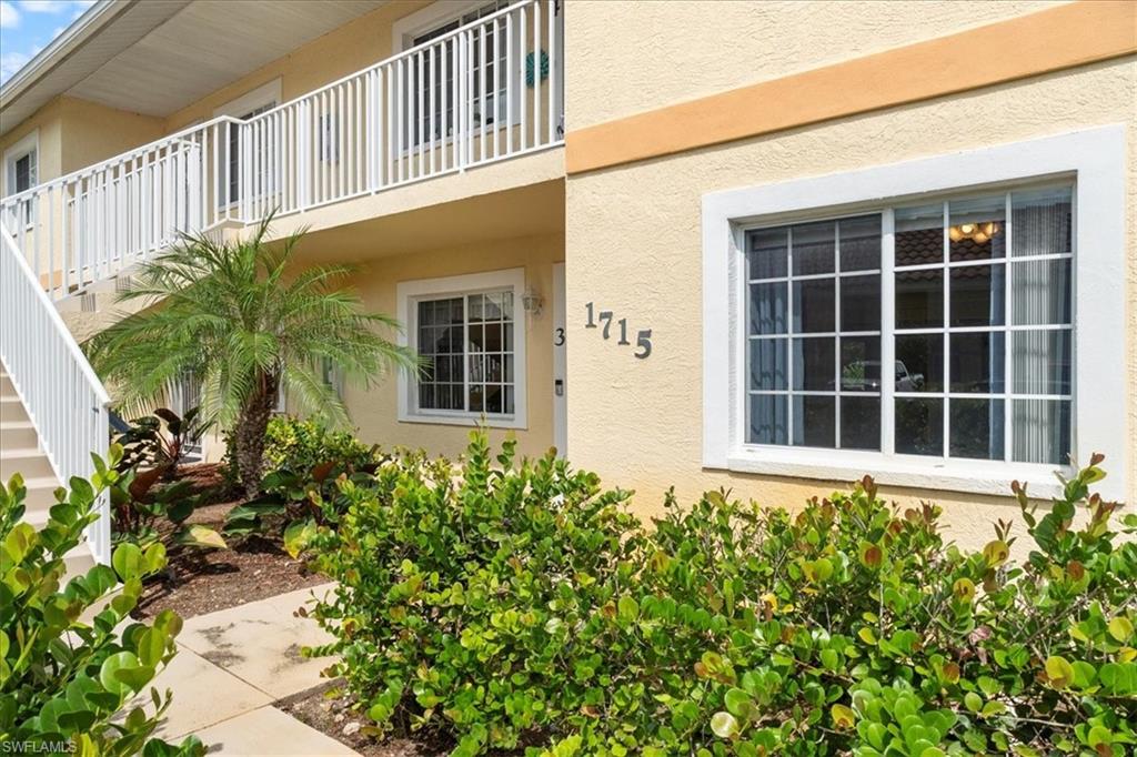 1715 Reuven Circle, Unit 2103 Naples, FL 34112 - Photo 28 of 38 a front view of a house with a flower garden