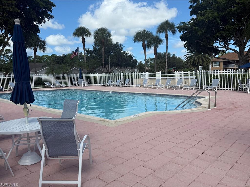 1715 Reuven Circle, Unit 2103 Naples, FL 34112 - Photo 29 of 40 a view of a swimming pool with a lounge chair