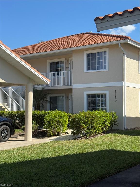 1715 Reuven Circle, Unit 2103 Naples, FL 34112 - Photo 36 of 40 a front view of a house with a yard