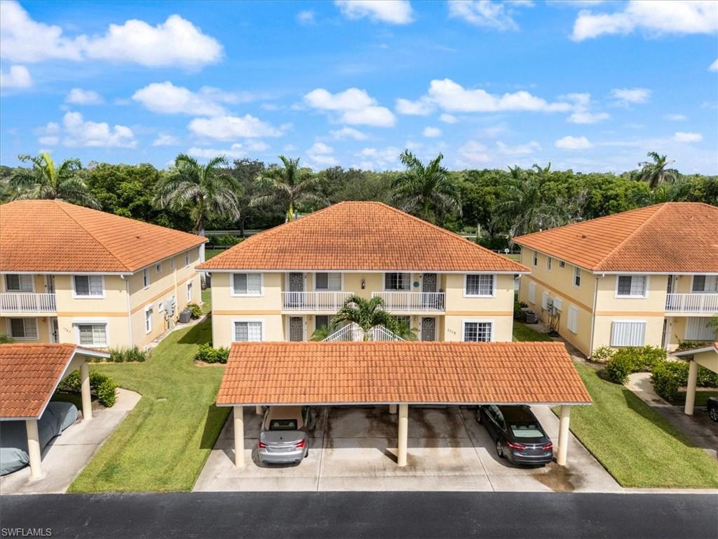 1715 Reuven Circle, Unit 2103 Naples, FL 34112 - Photo 38 of 40 an aerial view of multiple houses with a yard