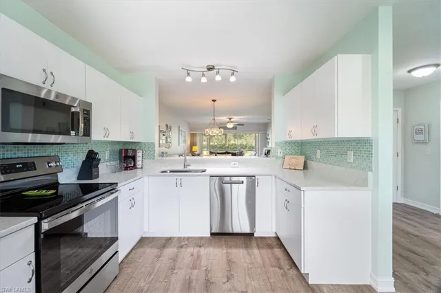 a kitchen with granite countertop a sink cabinets stainless steel appliances and a counter top space