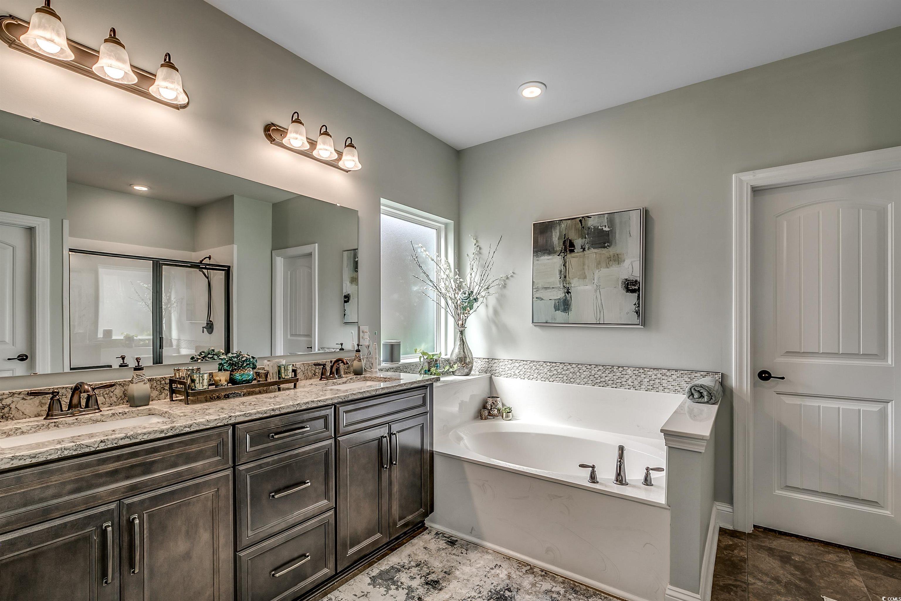 925 Abernathy Place Surfside Beach, SC 29575 - Photo 12 of 40 Full bath with double vanity, a garden tub, and a