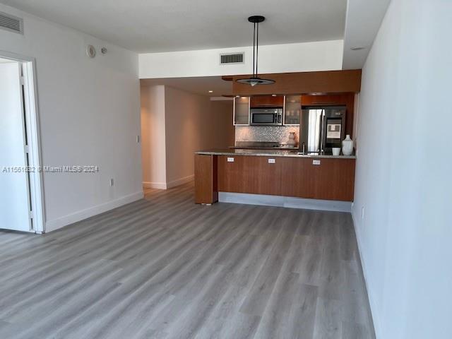 a kitchen with stainless steel appliances granite countertop a refrigerator and a sink