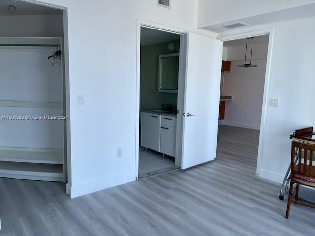 185 Southwest 7th Street, Unit 1403 Miami, FL 33130 - Photo 13 of 31 a view of an empty room with wooden floor and closet